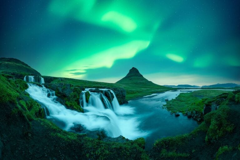 northern lights in iceland with a green landscape
