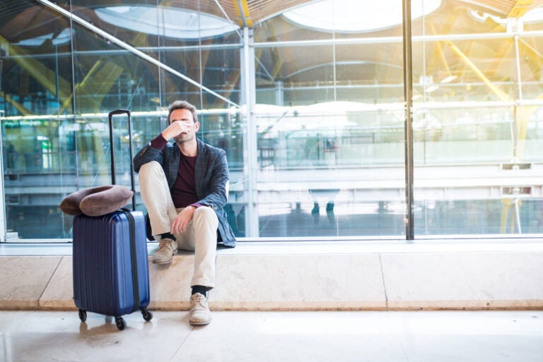 Frustrated traveler at airport looking stressed after long flight delay