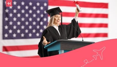 Female student holding a certificate at a podium in front of the USA flag - loans for international students in the USA