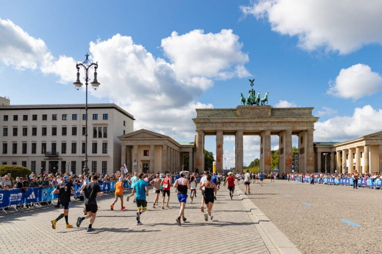 berlin marathon runners passing the brandenburg gate
