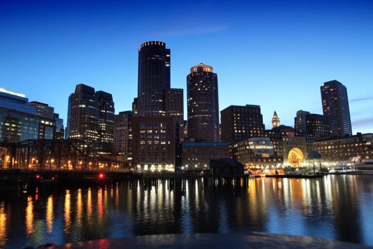 Boston skyline at night with illuminated waterfront and city buildings