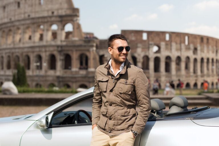 A man visiting the ruins of Italy in his rented car.
