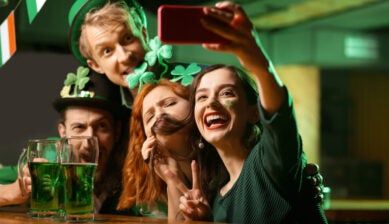 Group of friends wearing St Patrick’s Day costumes taking a photo together