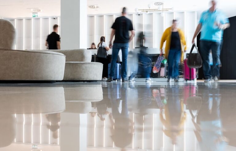 Hotel guests waiting in a lobby with suitcases during check-in