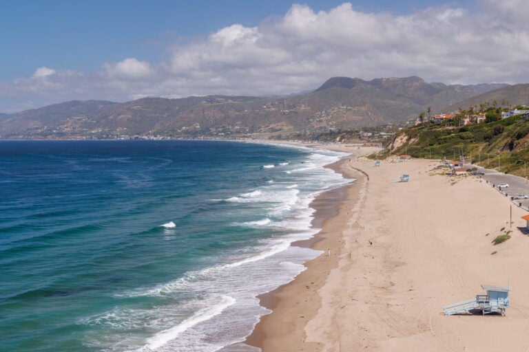 Sunny ocean coastline in Los Angeles with sandy beach and blue sky