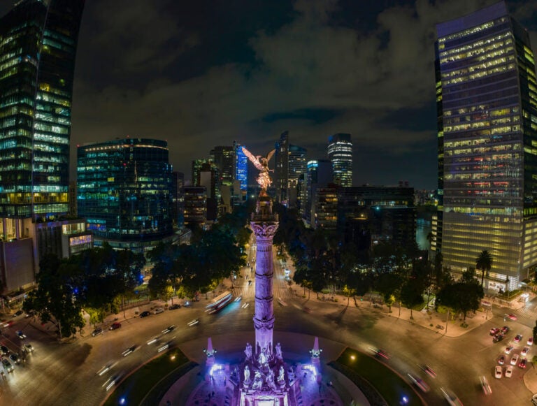 Panoramic night view of Reforma Avenue lined with trees and office buildings in Mexico City