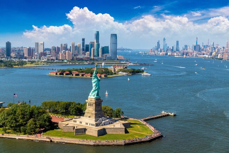 Aerial view of the Statue of Liberty with Jersey City and Manhattan skyline in the background
