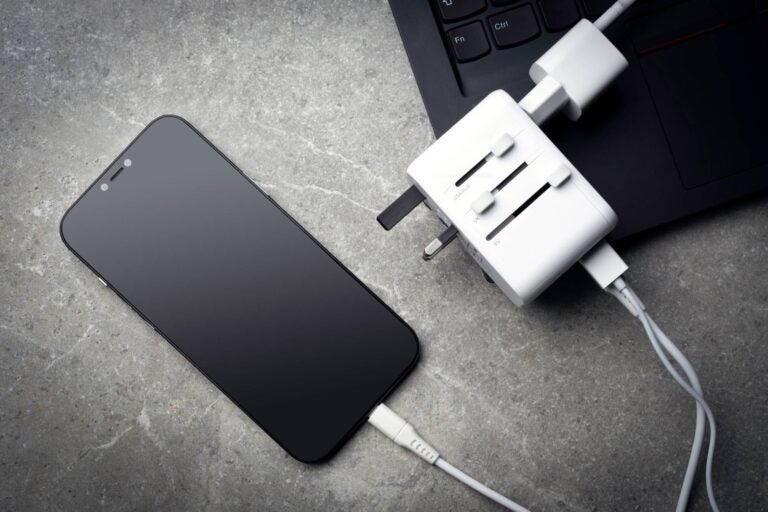 a phone plugged to a travel adapter