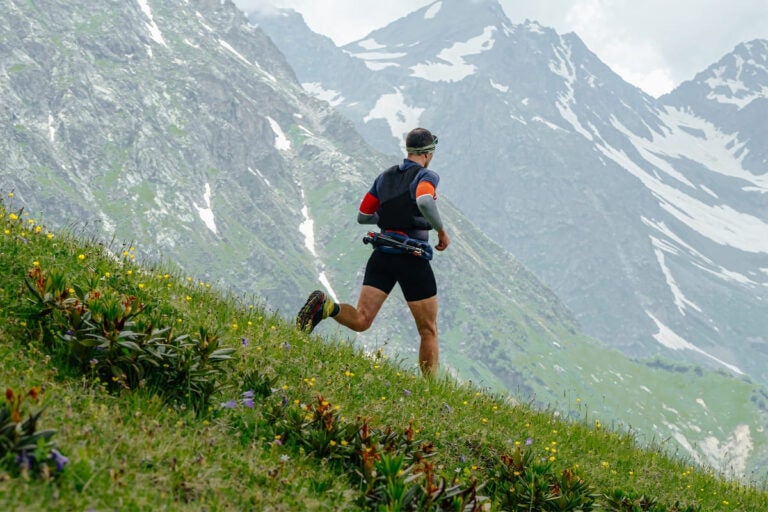 trail runners during the swiss alpine marathon with snow capped mountains