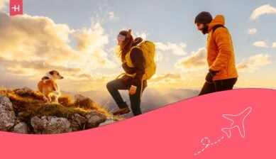 A couple traveling hiking with their dog while traveling through Canada.