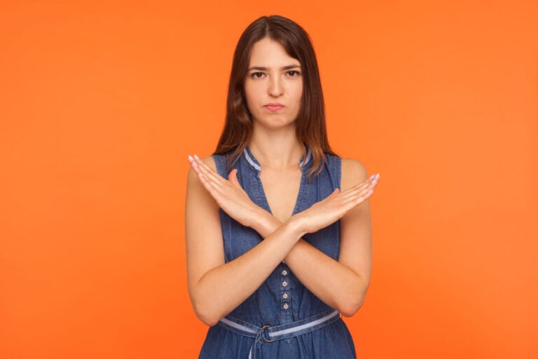 Woman crossing her arms in an X gesture indicating a clear no decision