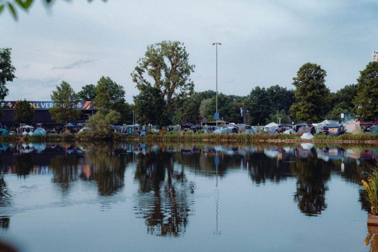Rock am Park festival campsite reflected in a calm lake.