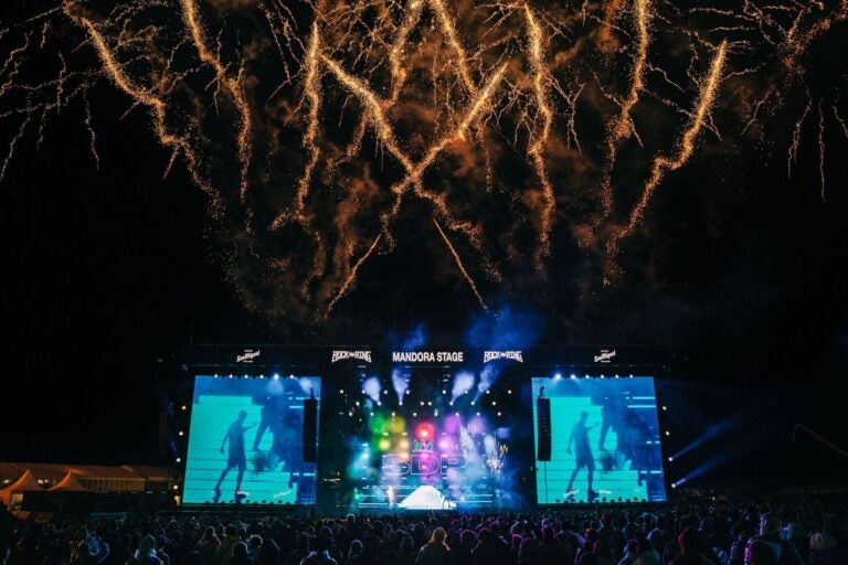 Singers performing under golden fireworks.