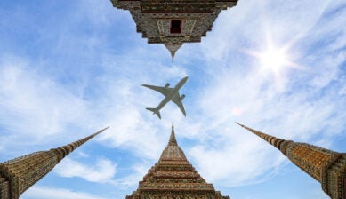 Commercial airplane flying over Bangkok's Grand Palace and Wat Phra Kaew in Thailand