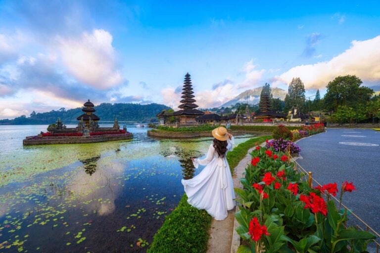 woman walking around a lake and temples in bali