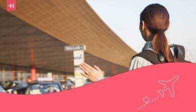 A woman being picked up by a shuttle to the car rental office near the airport.
