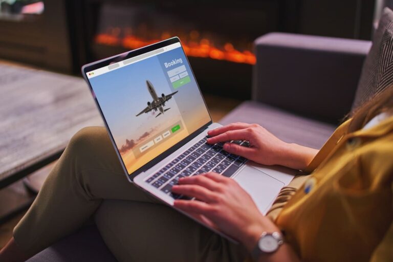 Person booking international plane tickets online on a computer