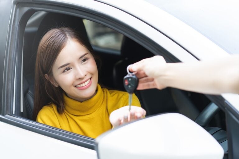 A woman receiving the key to her rental car in Alicante.