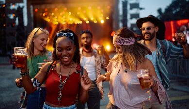 Diverse group of happy festival-goers dancing together in front of a music stage at Coachella