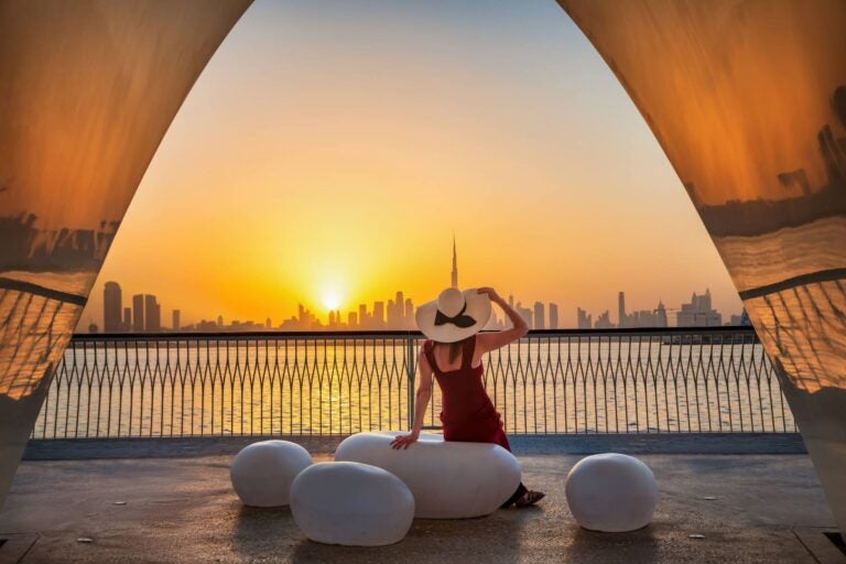 woman seeing the sunset with the dubai skyline in the background