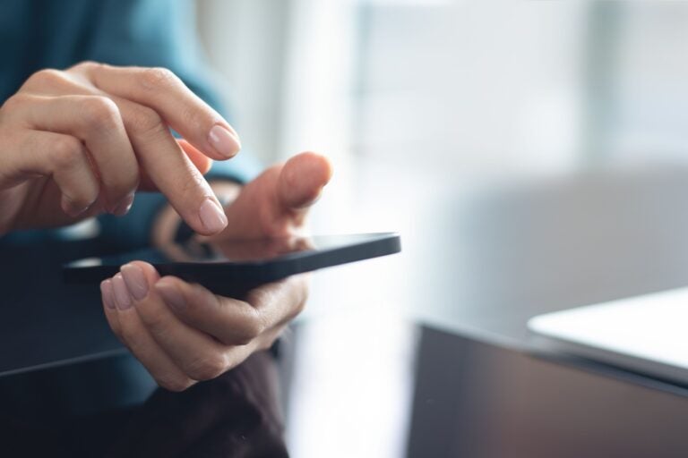 A student paying for a car in Australia through a bank transfer on his smartphone.