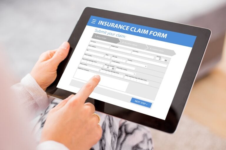 A woman filling an insurance claim form from an international driving insurance company.