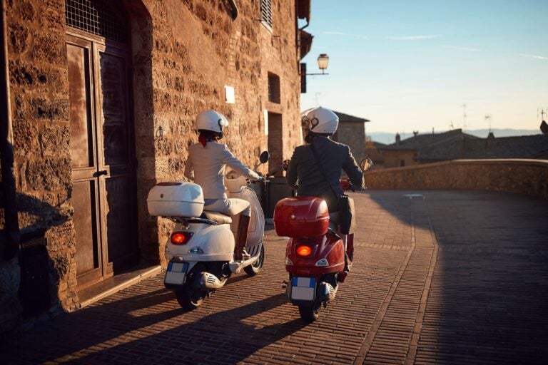 man and woman riding their mopeds using international driving permit
