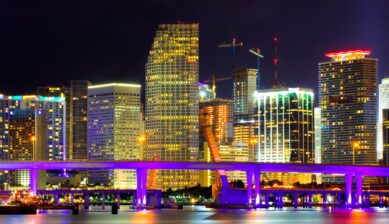 Colorful night view of Miami Florida downtown skyline with Biscayne Bridge and financial district lights