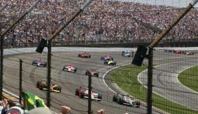 Racing cars on track with cheering fans in packed grandstands at the Miami Grand Prix