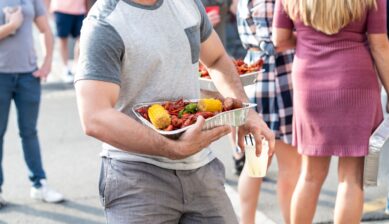 Diners holding trays of fresh lobster at a New Orleans, Louisiana seafood restaurant