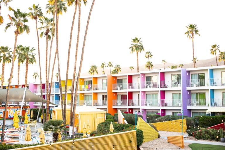 Colorful exterior of The Saguaro hotel with a pool area in Palm Springs, California