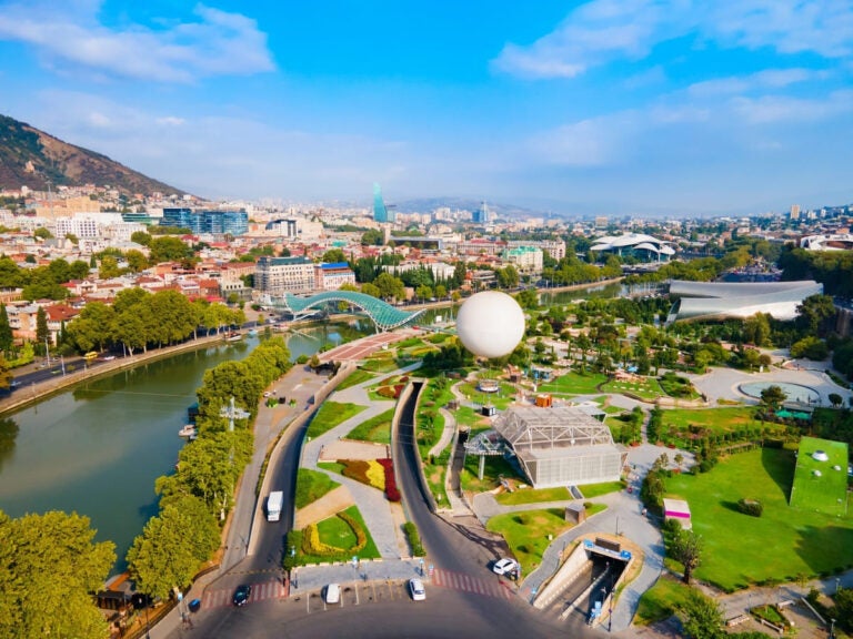 Aerial panoramic view of Tbilisi old town with the Kura River winding through the city, Georgia