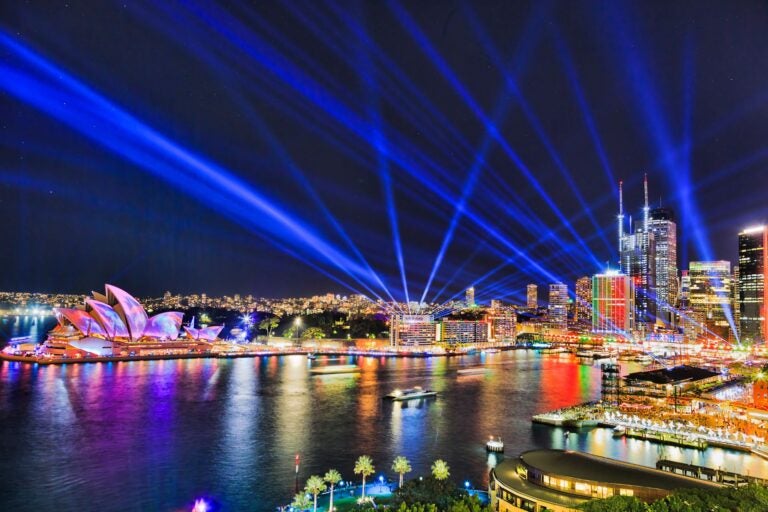 Sydney city CBD waterfront painted by light and laser beams in dark night sky.