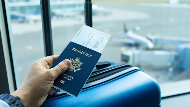 Person at airport holding an American passport while waiting to board a flight