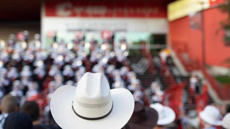 A white cowboy hat worn in a crowd of spectators at the Calgary Stampede