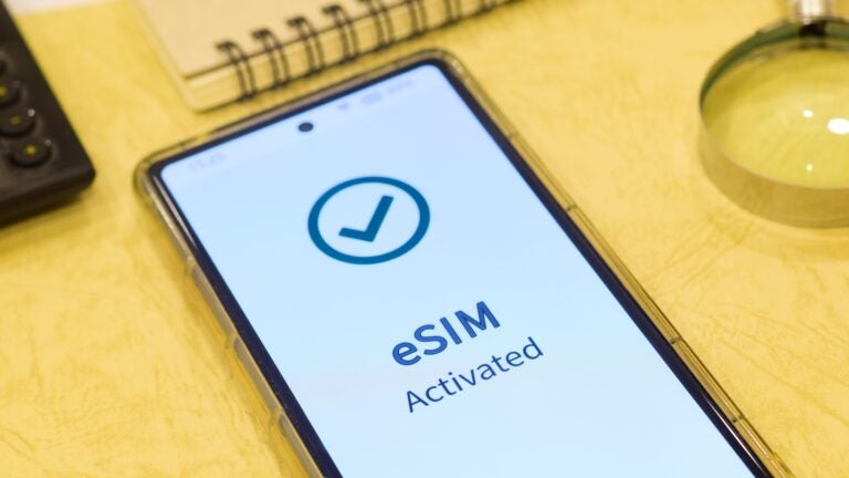 A close-up of a smartphone screen at night displaying an "eSIM activated" confirmation message, indicating a successful digital SIM installation.