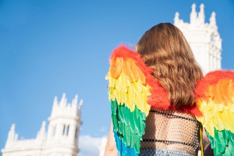 Young girl with rainbow wings on Madrid pride parade.