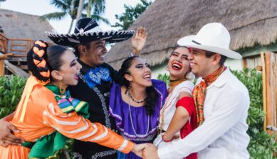 Group of young Mexican dancers wearing colorful traditional folk costumes at a cultural celebration in Latin America
