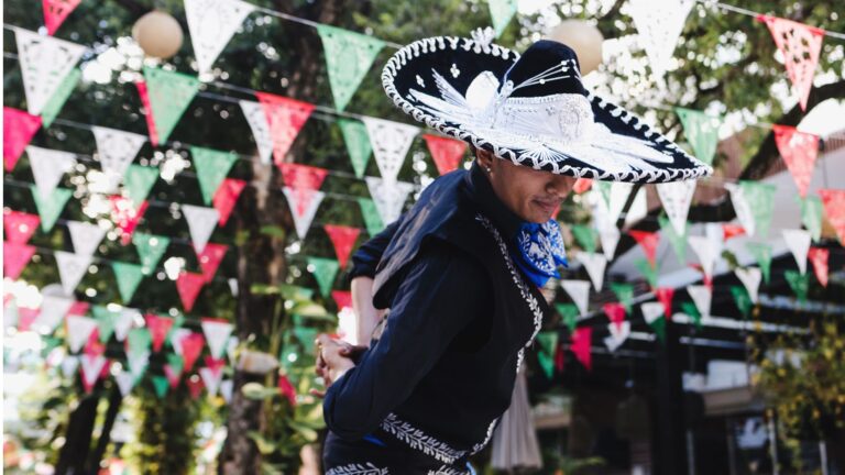 Latin man wearing a traditional Mexican mariachi costume at a cultural parade or Cinco de Mayo festival