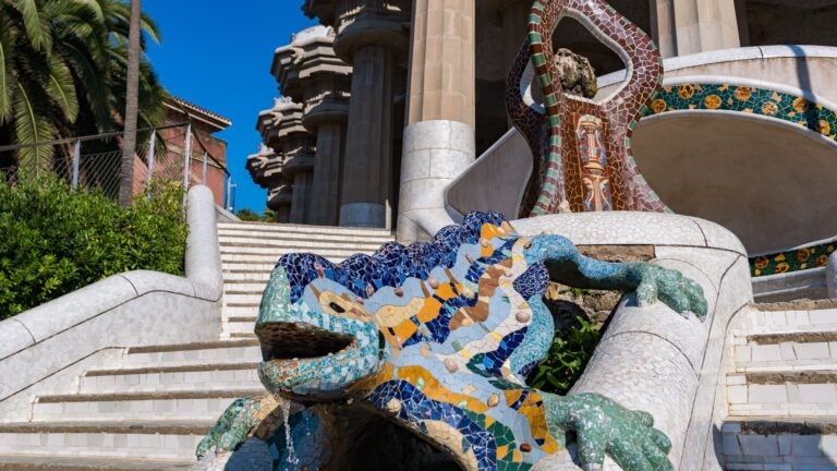 A scenic view of Park Güell in Barcelona, Spain, featuring the park's colorful mosaic architecture and sweeping views across the city.