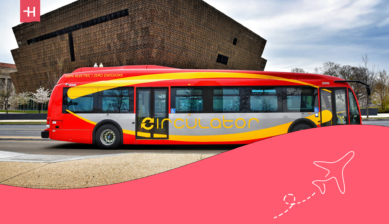 Manchester public bus on urban street near city landmarks.