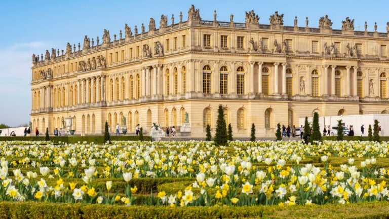 Aerial view of the Palace of Versailles and its formal gardens in bloom during spring, Paris suburbs, France