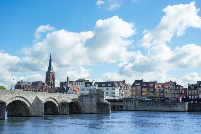 Scenic view of a historical stone bridge over a river Meuse.
