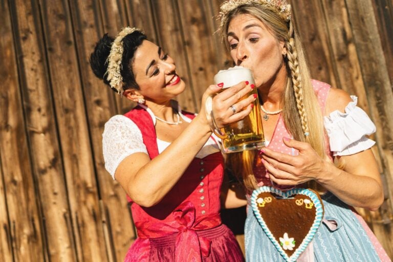 Girlfriends in dirndls during a festive moment.