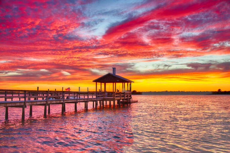 Wooden pier over the water at sunset in Wrightsville Beach, North Carolina.