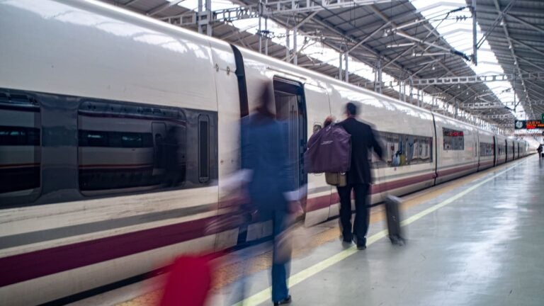 A high-speed AVE train blurred with motion as it passes through María Zambrano Station in Málaga