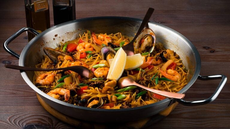 traditional fideuà served with seafood and some lemon