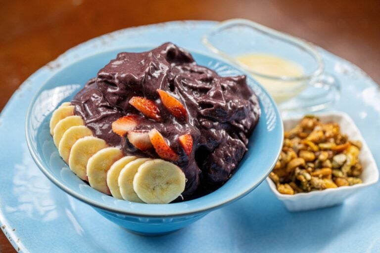 açai bowl with fruit on it and granola on the side