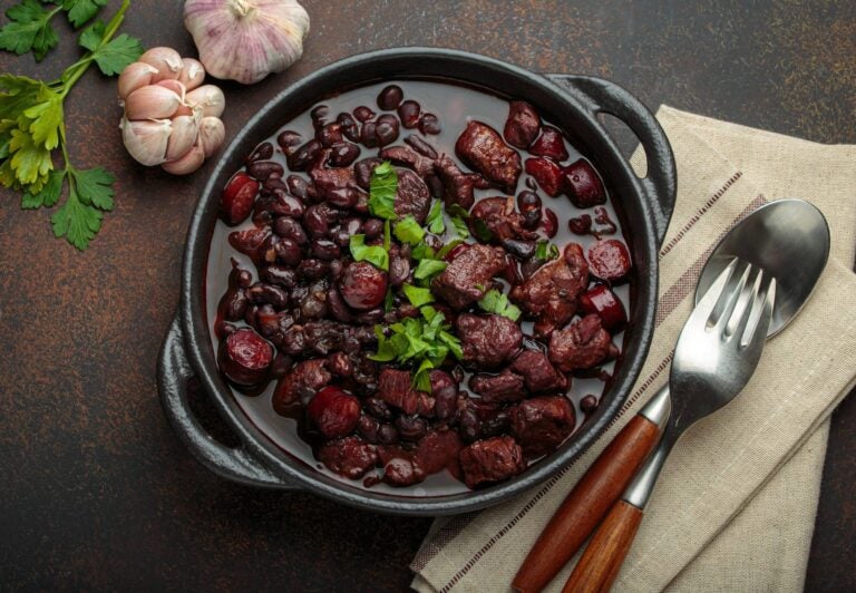 feijoada with black beans and meat, with a spoon and fork aside