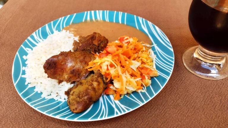 prato feito with chicken, salad, rice, and beans